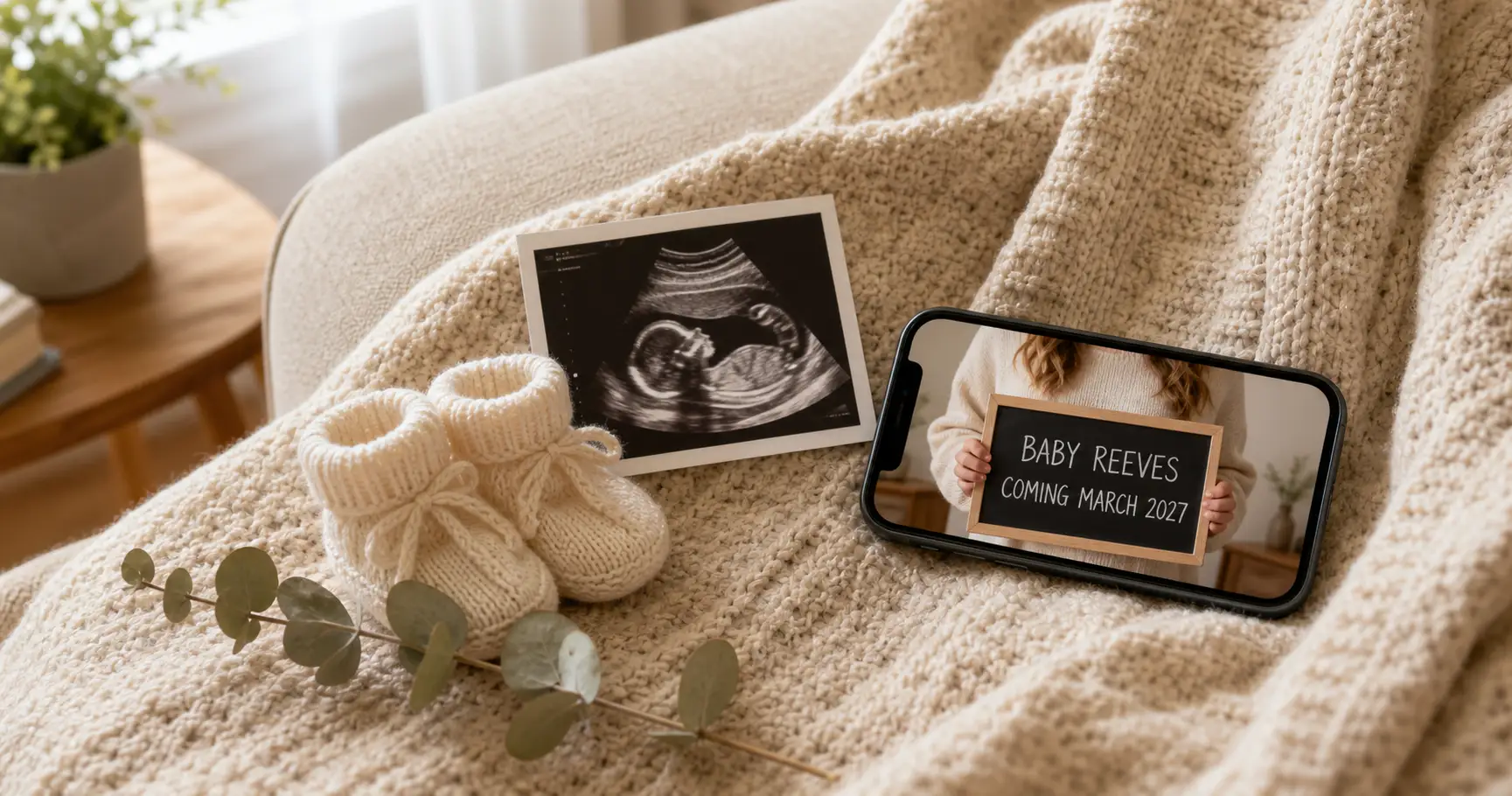 A finished pregnancy announcement on a phone screen beside a sonogram, tiny booties, and eucalyptus on a cozy sofa blanket, made at home from one photo.