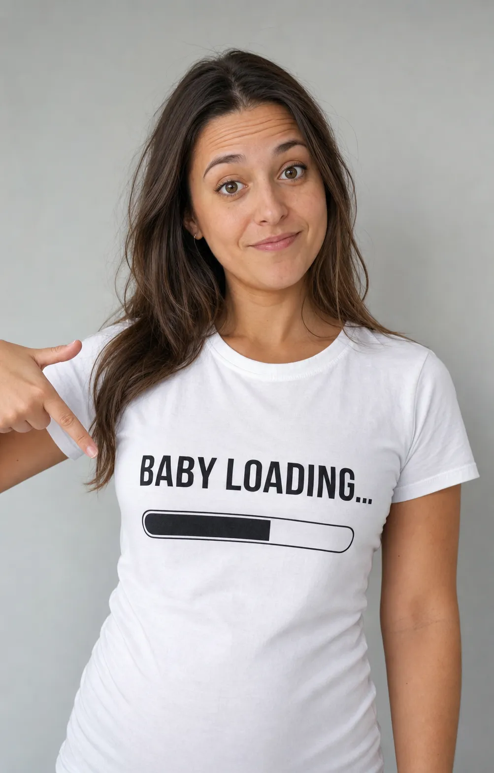 A funny text-forward pregnancy announcement: a person in a white tee printed Loading… Due 2027 with a half-filled progress bar.