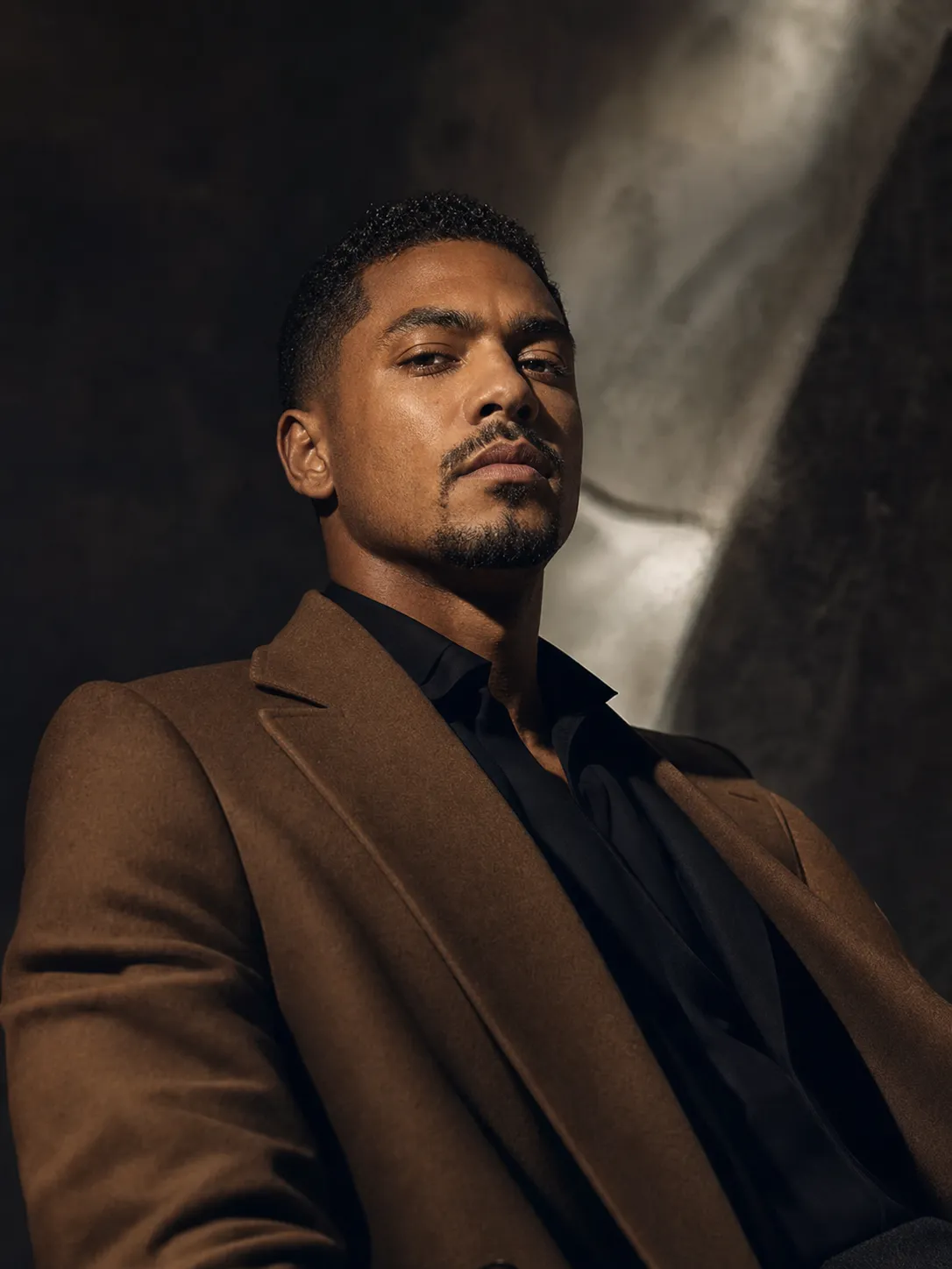 The same man rebuilt into a magazine cover-story editorial portrait in a tailored coat, keeping his real face.