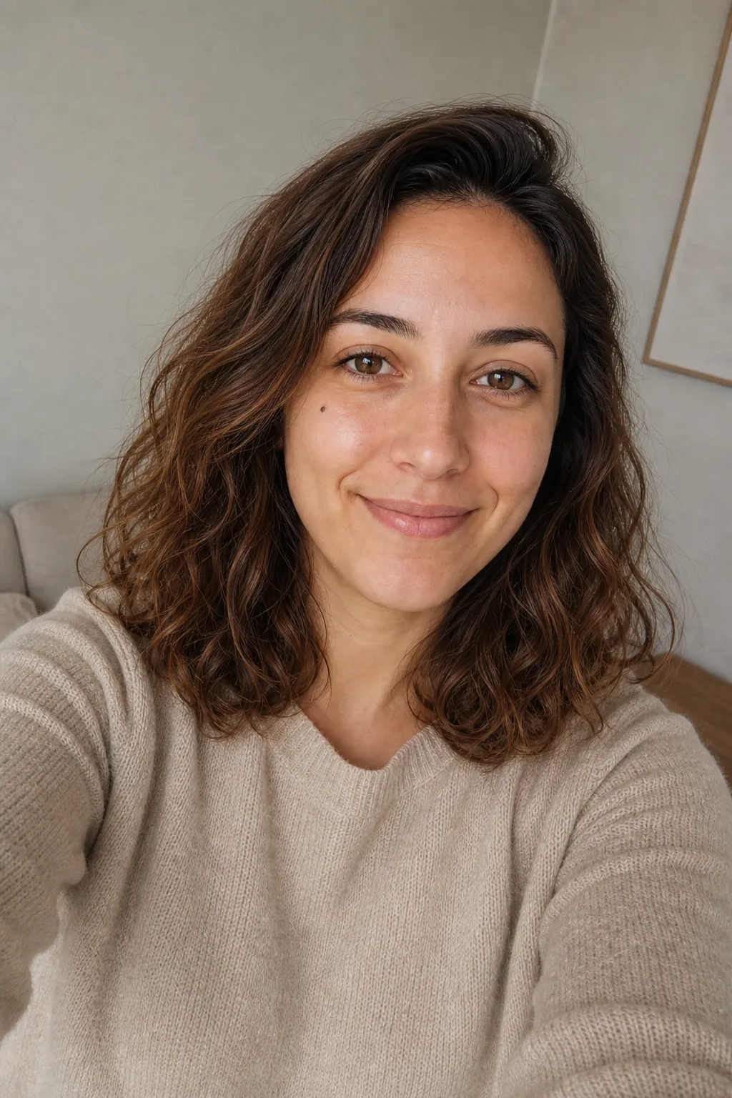A woman taking a selfie with the phone above eye level and her face turned three-quarters, the reliable flattering selfie angle.