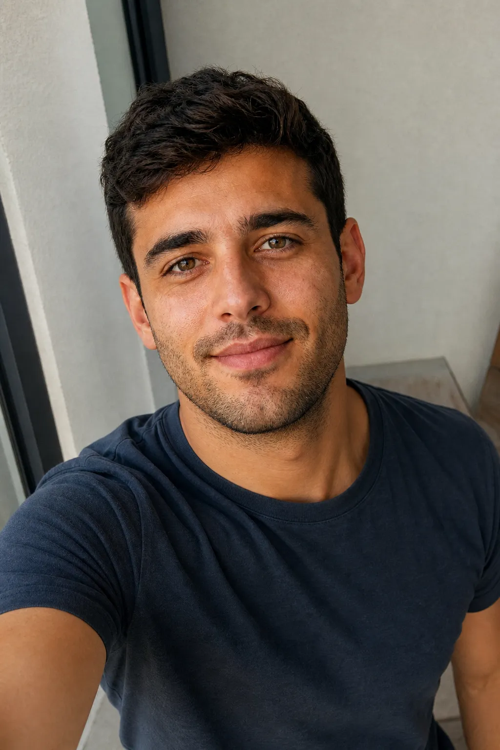 A man's selfie taken from slightly above eye level with his face turned three-quarters, the reliably flattering selfie angle.