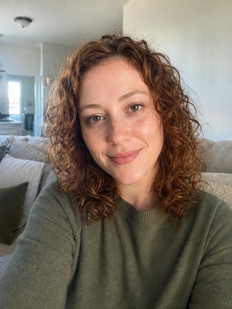 The same woman in soft directional window light, her features lit evenly and naturally.