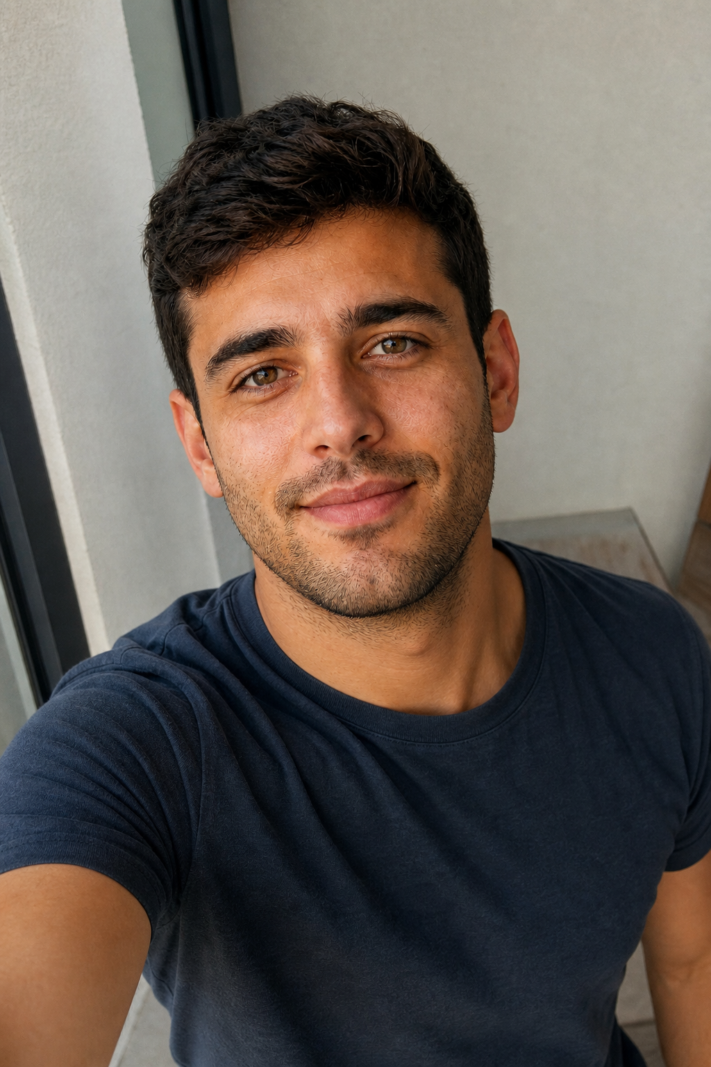 A man's selfie taken from slightly above eye level with his face turned three-quarters, the reliably flattering selfie angle.