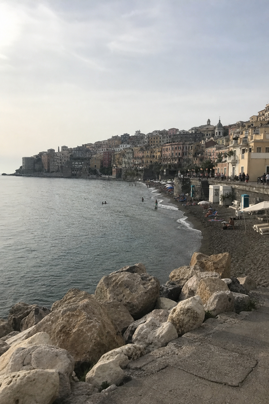 An ordinary dull vertical smartphone snapshot of a Mediterranean coastal town, the flat literal holiday photo most people start from before styling it.